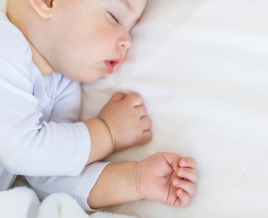 Baby ligt lekker te slapen op een kindermatras